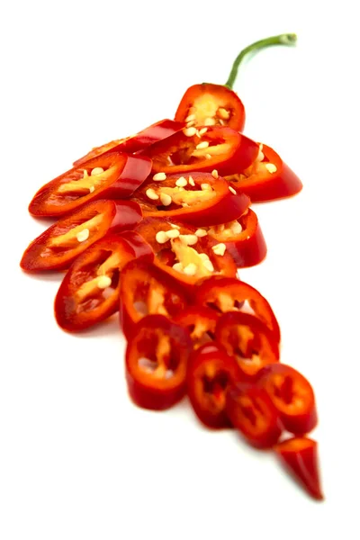 Dilimlenmiş kırmızı biber beyaz arka planda biber şeklinde katlanmış.