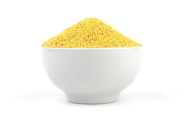 Beyaz arka planda beyaz bir kase ve çok güzel darı inlemeleri var. Stüdyo çekimi.