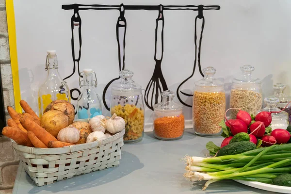 Sepetin içinde sebzeler ve tabakta bitkiler olan mutfak masası. Güzel arkaplan.