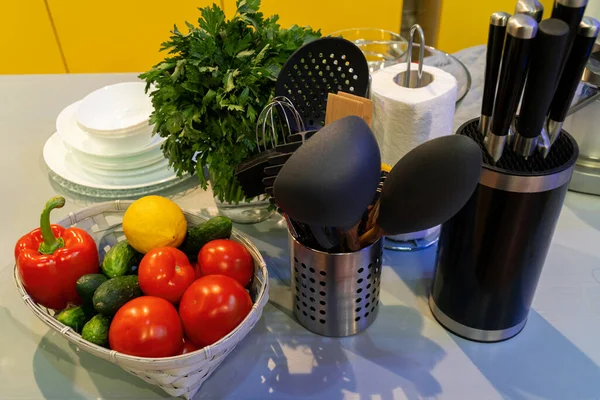 Sepetteki sebzeler mutfak masasındaki şifalı bitkilerin yanında. Stüdyo çekimi.