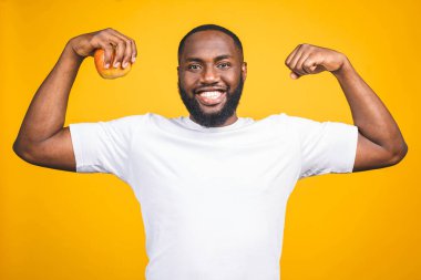 Sağlıklı Afrikalı Amerikalı bir adam sarı arka planda izole edilmiş bir elma tutuyor.. 