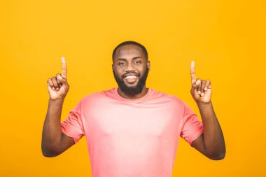 Mutlu, genç, yakışıklı Afro-Amerikan bir adamın portresi. Sıradan gülümsemesi, parmaklarıyla işaret etmesi, heyecanlı bir yüz ifadesiyle kameraya bakması.