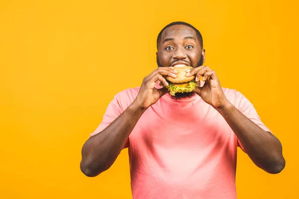 Joven Afroamericano Comiendo Hamburguesa Aislada Sobre Fondo Amarillo — Foto de Stock