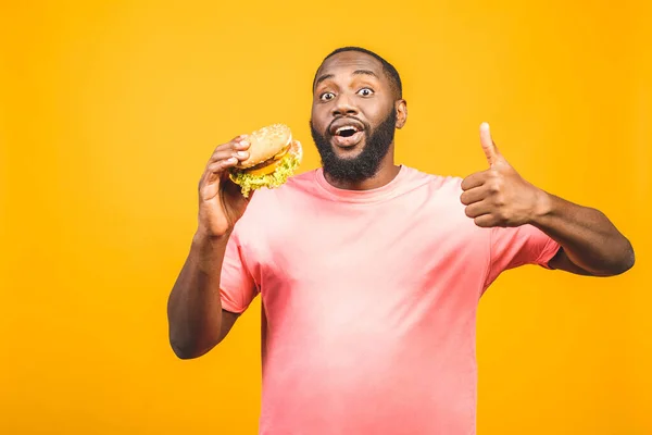 Joven Afroamericano Comiendo Hamburguesa Aislada Sobre Fondo Amarillo — Foto de Stock