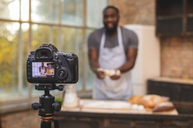 Pişirme işlemi. Genç aşçı Afrikalı hoparlör dijital kamera kayıtlarından konuşuyor. Afrikalı erkek vlogger ya da blog çekimleri muhabirlik reklam videosu, koçluk. 