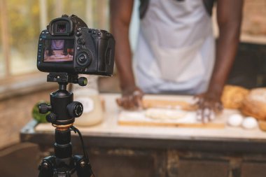 Pişirme işlemi. Genç aşçı Afrikalı hoparlör dijital kamera kayıtlarından konuşuyor. Afrikalı erkek vlogger ya da blog çekimleri muhabirlik reklam videosu, koçluk. 