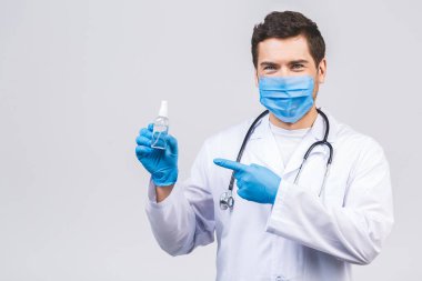 Doktor maskeli eldivenli adam beyaz arka planda izole edilmiş. Salgın koronavirüs 2019-ncov sarar covid-19 grip virüsü. Alkol sıvısı antibakteriyel dezenfektanla dolu bir şişe..