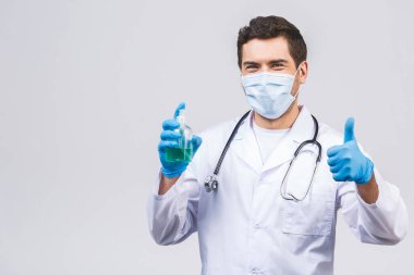 Doktor maskeli eldivenli adam beyaz arka planda izole edilmiş. Salgın koronavirüs 2019-ncov sarar covid-19 grip virüsü. Alkol sıvısı antibakteriyel dezenfektanla dolu bir şişe..