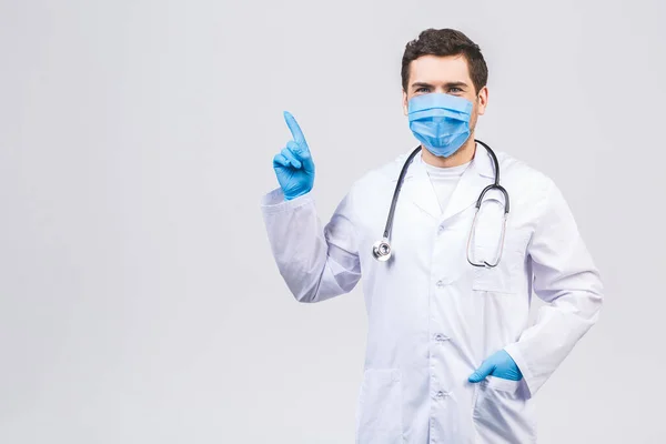 白い背景に隔離された医療用ガウン滅菌顔マスク手袋の医者の男 流行性大流行性コロナウイルス2019 Nconvは Covid 19インフルエンザウイルスを発見しました 指を上に向けて — ストック写真