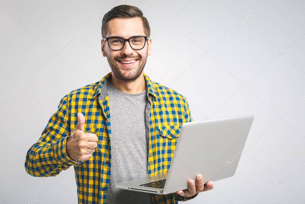 Confident business expert. Confident young handsome man in shirt holding laptop and smiling while standing against white background