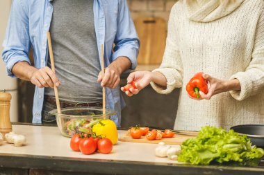 Hoş bir çift konuşuyor ve evde sağlıklı yemekler pişiriyorlar. Yakın plan.
