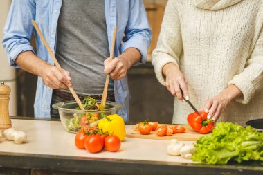 Hoş bir çift konuşuyor ve evde sağlıklı yemekler pişiriyorlar. Yakın plan.