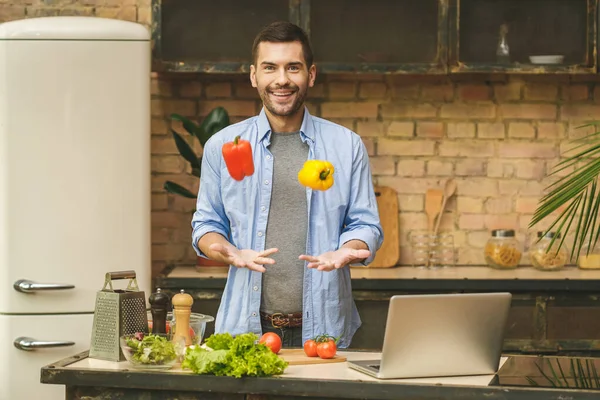 Komik Şef Biberlerle Eğleniyor Mutfakta Gülümsüyor Dizüstü Bilgisayar Kullanıyor — Stok fotoğraf
