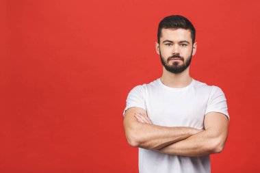 Fotokopi alanı olan bir portre, göz kamaştırıcı, seksi, güler yüzlü, havalı, kollarını kavuşturmuş, kırmızı arka planda izole edilmiş, kameraya bakan bir adam..