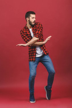 Kırmızı duvar arkasında dans eden yakışıklı genç adamın fotoğrafı.. 