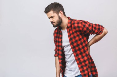 Sırt ağrısı çeken genç bir adam beyaz arka planda izole edilmiş. Sırt ağrısı kavramı. 
