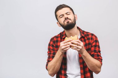 Hamburger tutan genç bir adam. Öğrenci fast food yiyor. Burger yararlı bir yemek değildir. Çok aç bir adam. Diyet kavramı beyaz arkaplanda izole edildi. 