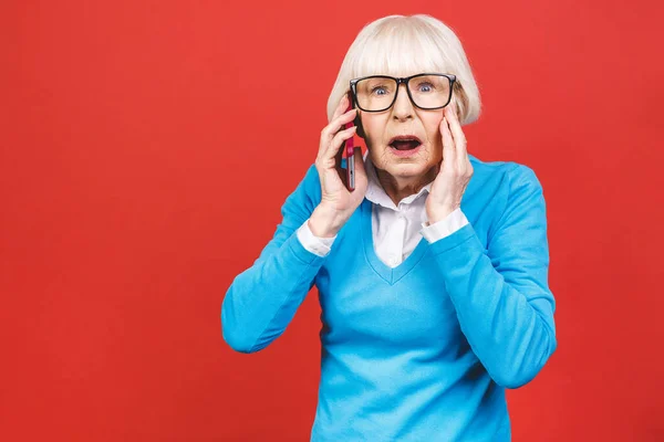 Yaşlı Bir Kadın Akıllı Telefonda Konuşuyor Kırmızı Arka Planda Dikiliyor — Stok fotoğraf