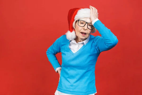 Starší Šedovlasá Žena Vánočním Klobouku Santa Nad Izolovaným Červeným Pozadím — Stock fotografie