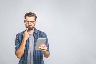 Bir fikrim var! Ekose gömlekli genç adamın gri arka plan üzerinde tablet kullandığını düşünüyorum..