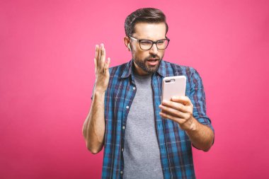 Yakışıklı adamın portresi akıllı telefonda şok olmuş görünüyor, takvim tarihini görüyor, buluşmaya gidemeyeceğini öğreniyor, reddetme mesajı yazıyor. İnsanlar, duygular ve teknoloji kavramı.