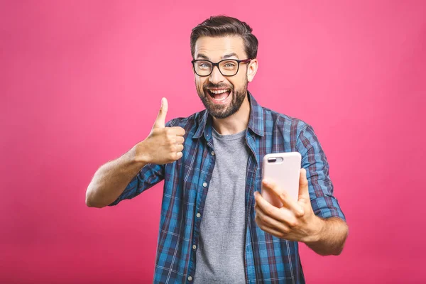 一个快乐的留着胡子的男人拿着自拍的画像 在粉色的背景上摆出大拇指的姿势 被隔离了 — 图库照片
