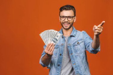 Turuncu duvar arkasında yalnız poz veren heyecanlı, genç sakallı adamın görüntüsü..