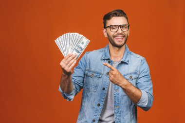 Turuncu duvar arkasında yalnız poz veren heyecanlı, genç sakallı adamın görüntüsü.. 