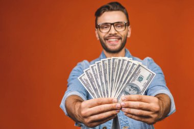 Turuncu duvar arkasında yalnız poz veren heyecanlı, genç sakallı adamın görüntüsü..