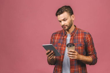 Reklamlar için fotokopi alanı olan pembe arka planda duran mutlu bir gülümsemeyle tablet tutan genç bir adamın portresi. Kahve ya da çay içmek.. 