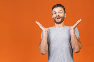 Şaşırmış yüzü olan genç bir adamın portresi turuncu arka planda izole edilmiş.. 