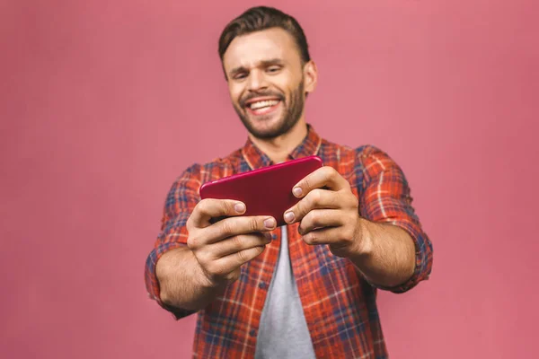 Portré Egy Izgatott Fiatalember Játszik Játékok Mobiltelefon Elszigetelt Rózsaszín Háttér — Stock Fotó