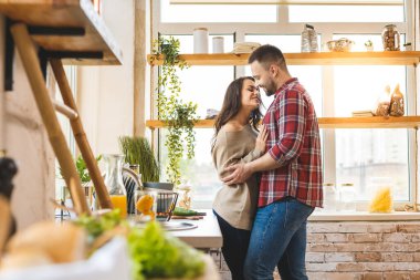 En iyi eğlence birlikte evde dinlenmektir. Güzel, genç bir çift evde mutfakta yemek pişiriyor..