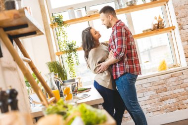 En iyi eğlence birlikte evde dinlenmektir. Güzel, genç bir çift evde mutfakta yemek pişiriyor..