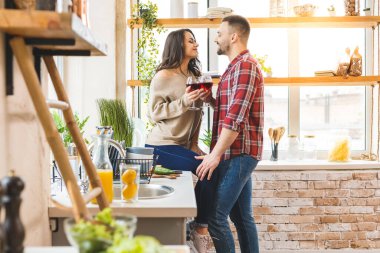 En iyi eğlence birlikte evde dinlenmektir. Güzel, genç bir çift evde mutfakta yemek pişirirken. Şarap içiyorum.. 