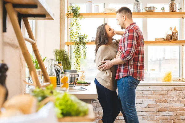 The best leisure is to relax at home together. Beautiful young couple cooking dinner while standing in the kitchen at home.