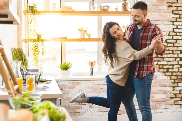 Mutfakta dans etmek. Nişan fotokopi alanını kutlayan genç romantik çift. Evde dans eden sevimli genç bir çift.. 