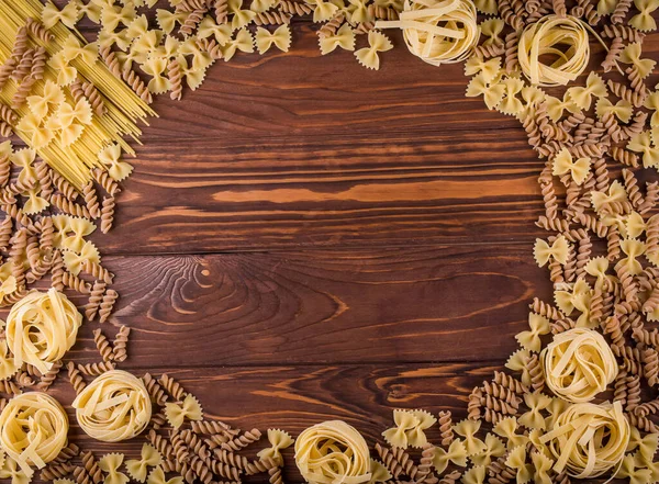 Pasta on wooden background. Top view with copy space. ingredients for bakery products.