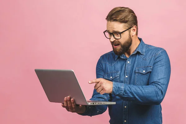 Confident business expert. Confident young handsome man in casual holding laptop while standing against isolated pink background.