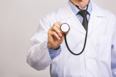 Kıdemli doktor gri arka planda izole edilmiş fonendoskop steteskop kullanıyor..