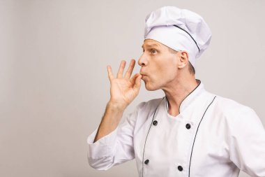 Kıdemli yakışıklı aşçı gri arka planda izole edilmiş.. 