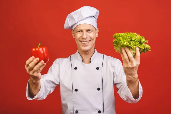 Kırmızı Arka Planda Salata Kırmızı Biber Tutan Gülümseyen Bir Aşçının — Stok fotoğraf
