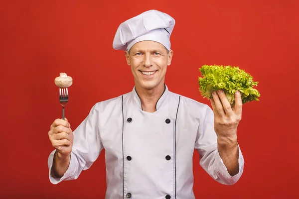 Kırmızı Arka Planda Salata Mantar Tutan Gülümseyen Bir Aşçının Portresi — Stok fotoğraf