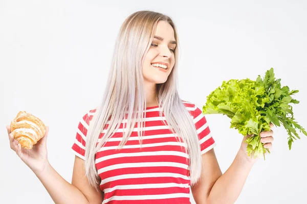 健康で不健康な食べ物を選ぶ混乱した美しい若いブロンドの女性の肖像画 白地に隔離された — ストック写真