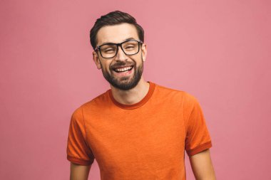 Mutlu genç adam. Pembe arka planda dikilmiş gülümseyen yakışıklı genç adamın portresi..