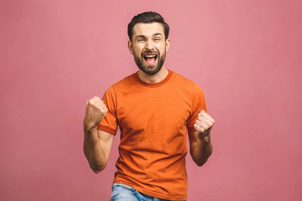 İşte bu! Mutlu galip! Mutlu genç yakışıklı adam pembe arka planda dikilirken el kol hareketi yapıyor ve ağzını açık tutuyor..