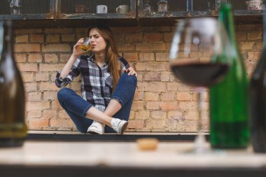 Genç kadın alkolik sosyal sorunlar kavramı mutfakta gözleri kapalı oturuyor. Depresyonda olan genç bir kız çocuğu acı çekerek ve ağlayarak kötü muamele görüyor.. 