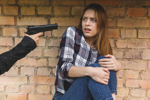 Вор-грабитель, приставивший пистолет к голове, собирается убить женщину-заложницу, преступление
.