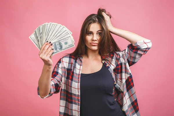 お金の紙幣を持っている陽気な若い女性の肖像画とピンクの背景に孤立して祝う — ストック写真