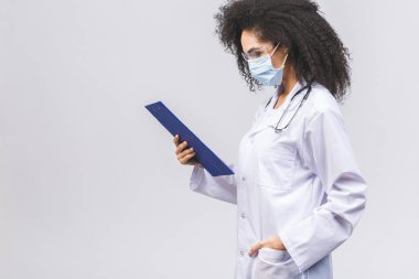Güzel Afrikalı genç siyahi kadın doktor ya da hemşire beyaz ya da gri arka planda izole edilmiş..